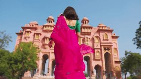 Indian woman tourist wearing traditional saree and exploring architectural monuments in Jaipur, Rajasthan, India. Travel and tourism concept. Girl walking at Patrika Gate in Jaipur. - Powered by Shutterstock - Get 15% off with code: PIKWIZARD15