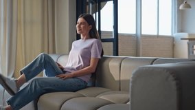Joyful woman falling couch feeling happy at home. Carefree brunette girl taking rest chilling sofa at light living room. Satisfied hipster lady relaxing at cozy apartment interior. Domestic lifestyle  - Powered by Shutterstock - Get 15% off with code: PIKWIZARD15