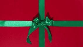 Unwrapping gift revealing a green screen - Stop Motion Animation - Green ribbon with bow on red background. Chroma key.	 - Powered by Shutterstock - Get 15% off with code: PIKWIZARD15