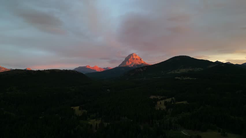 Spectacular mountain peak glowing in the evening sun, aerial drone view. Crowsnest Pass, AB, Canada.