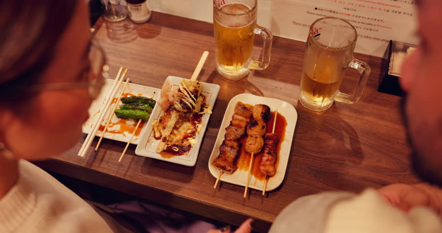 Asian couple, hand or eating food on restaurant date, share options or relax together. Japanese man, woman and cafe dinner with traditional meal, meat choice or dining at pub for conversation closeup
