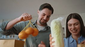 Family couple bringing groceries in white kitchen interior closeup. Happy man woman carrying paper bags with healthy food putting at counter at home. Lovely pair sharing domestic chores in apartment - Powered by Shutterstock - Get 15% off with code: PIKWIZARD15