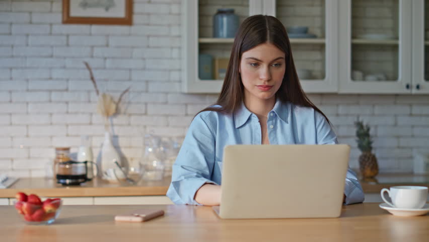 Woman winner checking smartphone notification at computer table remote office closeup. Excited girl taking mobile phone reacting emotionally on great news. Successful happy lady winning achievement