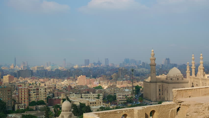 Panning handheld footage of mosques, residential buildings and skyscrapers of Cairo. Islamic Cairo cityscape