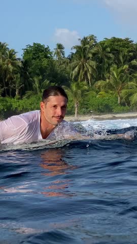 Male surfer swimming on surfboard in the ocean, Indonesia. High quality 4k footage