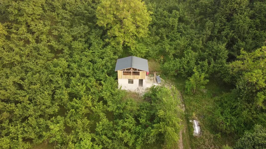 Drone view of a house in the woods.