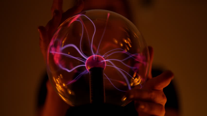 Close-up of mysterious fortune teller holding glowing plasma ball, creating mystical atmosphere for divination and spiritual guidance, during session in dimly lit room. Shooting in slow motion.