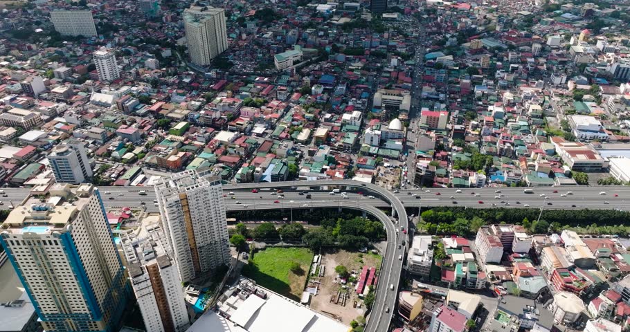 Drone view of vehicles running on skyway. Hotels and residential area in Makati, Metro Manila. Philippines.