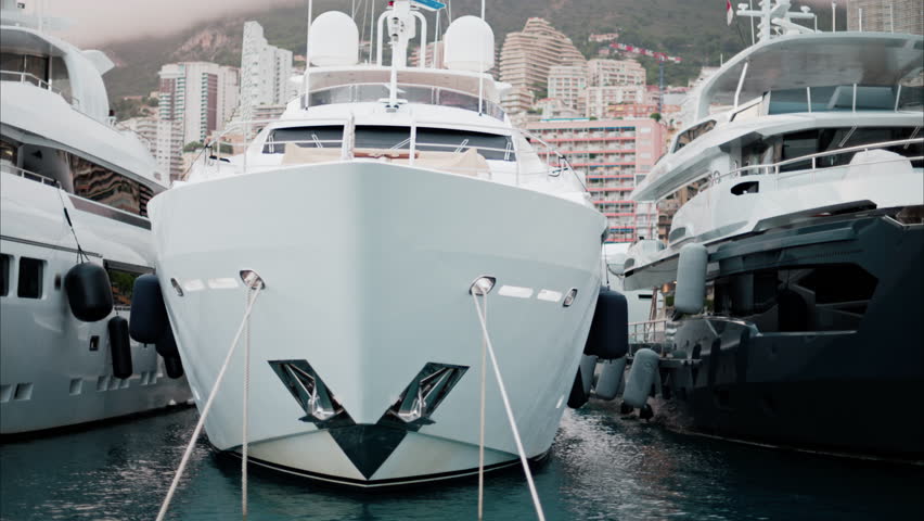 View of boats docked in the Monaco Marina with the skyline of the city on the background