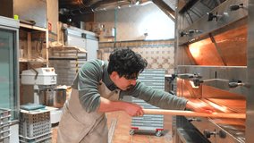 Latin young man baking bread in a traditional oven using a wooden peel - Powered by Shutterstock - Get 15% off with code: PIKWIZARD15