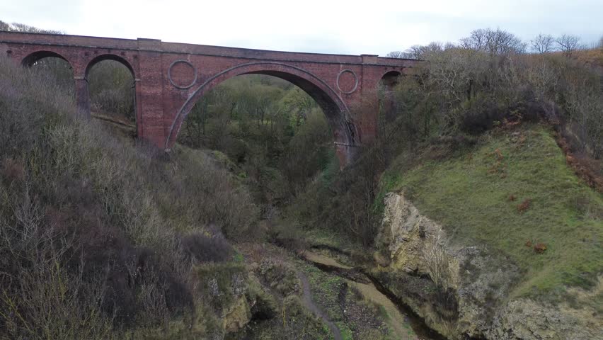 Rising drone shot of Hawthorn Viaduct and Dene during autumn. County Durham, UK