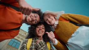 Bottom view smiling happy multiracial friends three students girls Caucasian female women African American boy guy man in city in college university leaning heads showing thumbs up likes good gesture - Powered by Shutterstock - Get 15% off with code: PIKWIZARD15