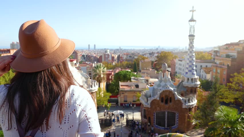 A tourist woman enjoys a sightseeing trip through the popular Park Guell in Barcelona, Spain, on a sunny day