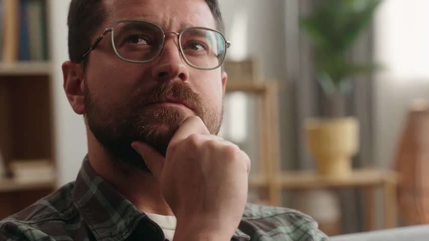 Portrait at home pensive thinking idea solution think ponder bearded man guy thoughtful confused puzzled hesitate male at home apartment loan mortgage insurance searching looking decision holding chin