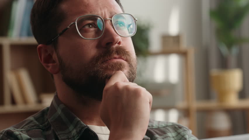 Portrait at home pensive thinking idea solution think ponder bearded man guy thoughtful confused puzzled hesitate male at home apartment loan mortgage insurance searching looking decision holding chin