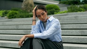 Tired exhausted fatigued African American woman female waiting meeting sad disappointed lady girl business businesswoman in city sitting stairs stairway suffer stress looking at wrist watch check time - Powered by Shutterstock - Get 15% off with code: PIKWIZARD15