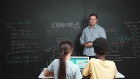 Caucasian teacher answering student question about coding program. Caucasian girl raised hand to ask, vote, volunteer, answer while laptop display system screen at STEM technology class. Edification - Powered by Shutterstock - Get 15% off with code: PIKWIZARD15