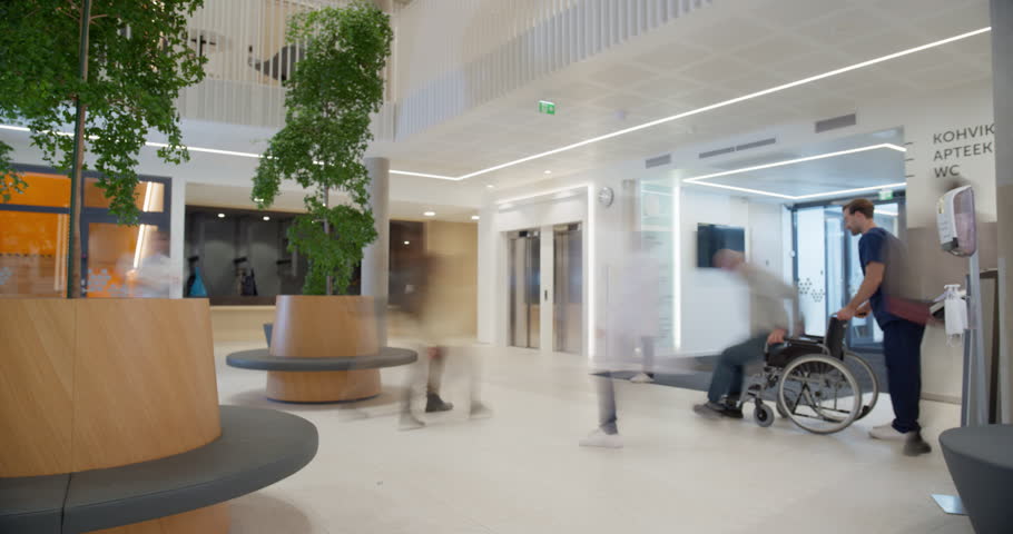 Timelapse of Modern Hospital Lobby with a Busy Flow of Patients, Visitors, and Staff. Doctors, Nurses and Specialists Working in Clinic. Female and Male Healthcare Officials Walking in a Hall