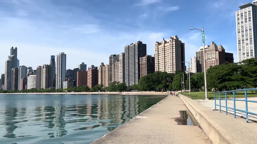 This photo captures the stunning Chicago skyline along Lake Michigan. The towering skyscrapers rise above the city, creating a breathtaking panorama. The calm waters of the lake reflect the buildings.
