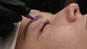 The master combs the client's eyelashes after lamination.  - Powered by Shutterstock - Get 15% off with code: PIKWIZARD15