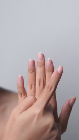 Close up of young Asian woman hand showing and pointing to her natural and clean nails.