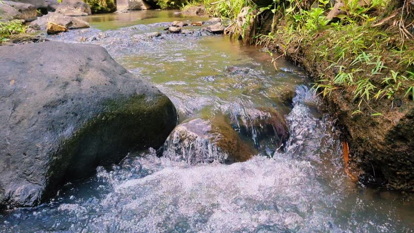 River water flows fast between large rocks
