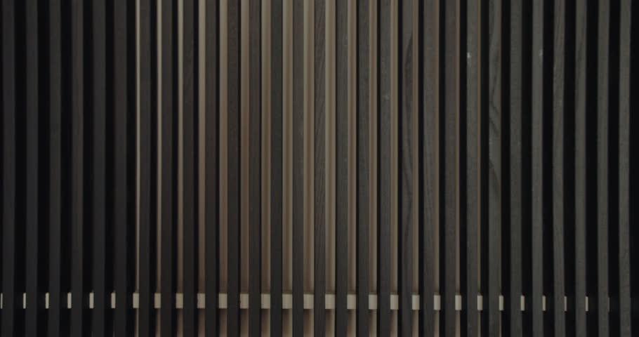 Close-up image of a dark wood striped wall, showcasing a minimalist and modern design with rhythmic symmetrical patterns. Modern Dark Wooden Striped Wall with Symmetric Patterns