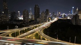 A vibrant timelapse of Shanghai's Nine Dragon Intersection looking toward the Bund. Elevated highways with glowing light trails merge into the cityscape, framed by skyscrapers and greenery. - Powered by Shutterstock - Get 15% off with code: PIKWIZARD15