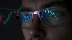 Close-up portrait of focused crypto trader analyst wearing eyeglasses looking at computer screen analyzing stock market charts. Eyeglasses reflection with cryptocurrency bitcoin charts.  - Powered by Shutterstock - Get 15% off with code: PIKWIZARD15