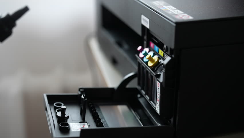 Detailed shot of female hand putting black ink cartridge into a home printer, demonstrating ink replacement or refilling process for printing needs. Technician filling printer cartridge with ink.