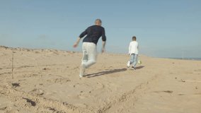 Father and Son Play Soccer on Sunny Beach. Father Celebrating Scoring Goal, While His Son Runs Up  - Powered by Shutterstock - Get 15% off with code: PIKWIZARD15