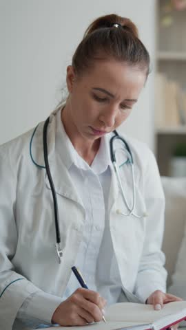 Woman physician asking patient and making notes in pad, emergency doctor in patients house. Healthcare and curing, paramedic consulting and communicating with sick people, health professional at work
