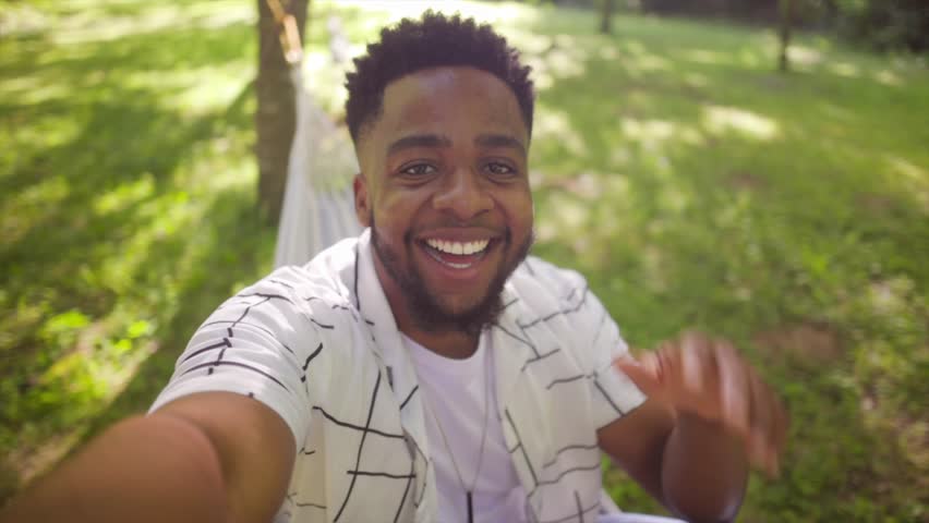 african man in nature recording a selfie video