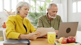 Mature couple discussing paperwork at home - Powered by Shutterstock - Get 15% off with code: PIKWIZARD15