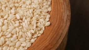 A CloseUp Image Featuring Raw White Sesame Seeds in a Wooden Bowl - Powered by Shutterstock - Get 15% off with code: PIKWIZARD15