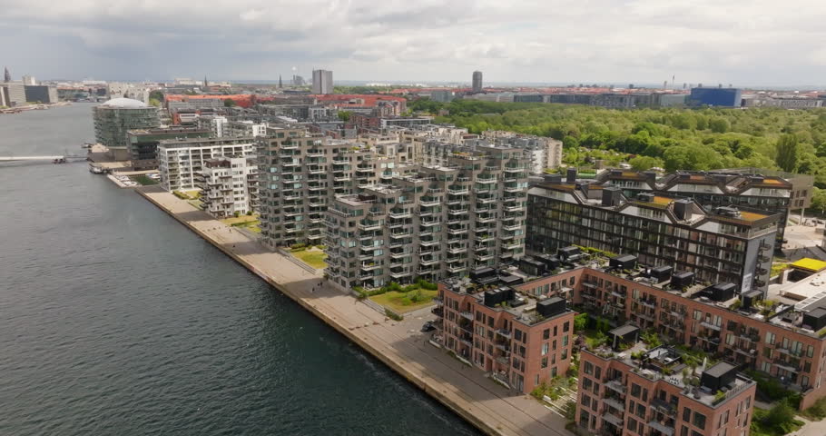 Aerial view backwards in front of riverside condos in sunny Copenhagen, Denmark