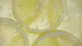 Drops of liquid falling on fresh sliced lemon pieces in slow motion. Beautiful ice water splash on lemon slices in macro. Vitamin C or serum acid in cosmetic product - Powered by Shutterstock - Get 15% off with code: PIKWIZARD15