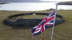 Waving union jack flag flutters over british war graves near the ocean, honoring the memory of fallen soldiers and their sacrifice - Powered by Shutterstock - Get 15% off with code: PIKWIZARD15