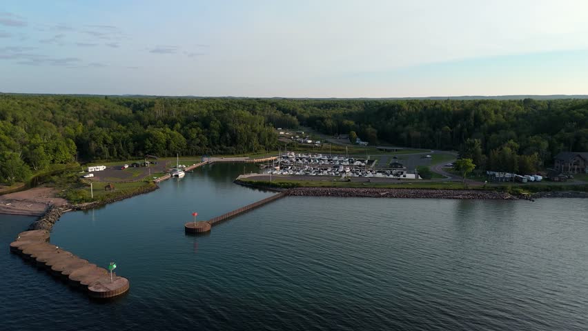 Drone aerial view of a calm Lake Superior at Saxon Harbor Wisconsin with breakwater, marina and northern Wisconsin forest