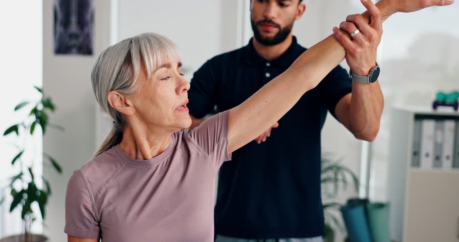 Shoulder pain, stretching and physiotherapist with mature woman for rehabilitation, recovery or medical care. Health, clinic and chiropractor and patient for physical therapy, consulting and wellness