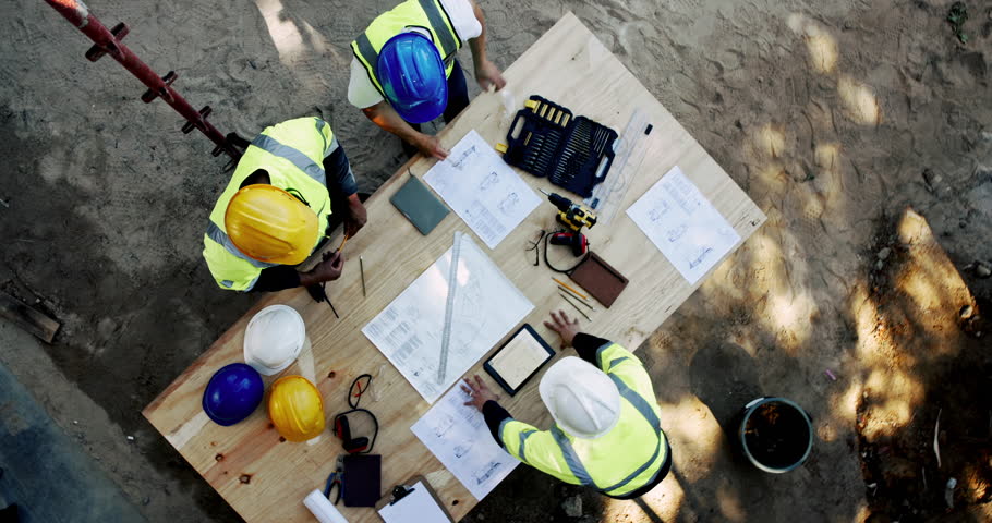 Above, men and engineer on construction site with paper, urban development and project management with tablet. Architect team, blueprint and talking at equipment for building renovation with planning
