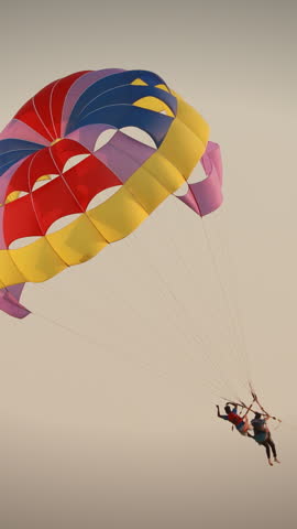 Parasailers Flying On Colorful Parachute In Sunset Or Sunrise Sky. Active Hobby.