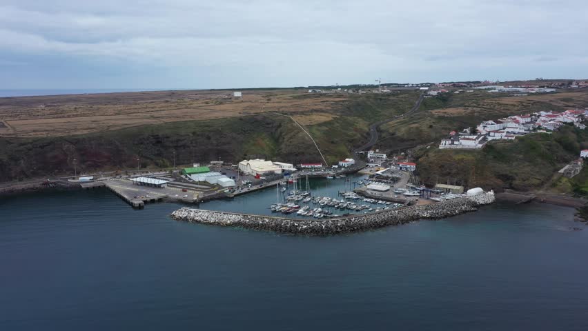 Drone footage capturing the picturesque fishing port of Vila do Porto, located on Santa Maria Island in the Azores, Portugal.