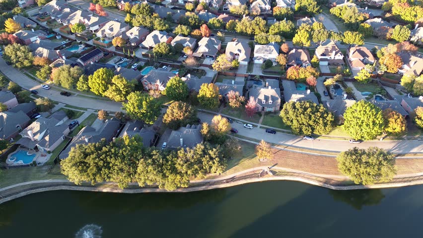 Upscale suburban residential neighborhood in Coppell, Dallas County, Texas, colorful fall foliage autumn leaves, cluster two-story house swimming pools, large backyard, solar panel roof, flyover. USA