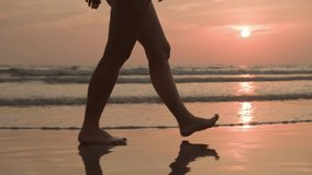 Evening walk of tourist woman at seaside resort along sandy beach on background of pink sunset sky over ocean with waves. - Powered by Shutterstock - Get 15% off with code: PIKWIZARD15