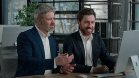 Happy Caucasian men businessmen business partners discussing financial growth looking at computer screen in office smiling colleagues males entrepreneurs discuss plan project strategy working together - Powered by Shutterstock - Get 15% off with code: PIKWIZARD15