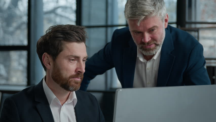 Angry man boss leader scold employee quarrel with worker unhappy with bad presentation on computer incorrect report error problem Caucasian men businessmen arguing in office meeting business conflict
