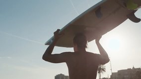 Surfer man walking to the beach at sunset preparing for surfing training and search for waves in Barcelona, spain, water, ocean exercise in sea with board, athletic male holiday or travel in vacation. - Powered by Shutterstock - Get 15% off with code: PIKWIZARD15