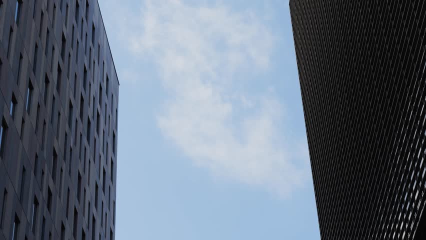 Modern glass office scyscraper buildings beautifully reflecting the clear blue sky in an urban environment