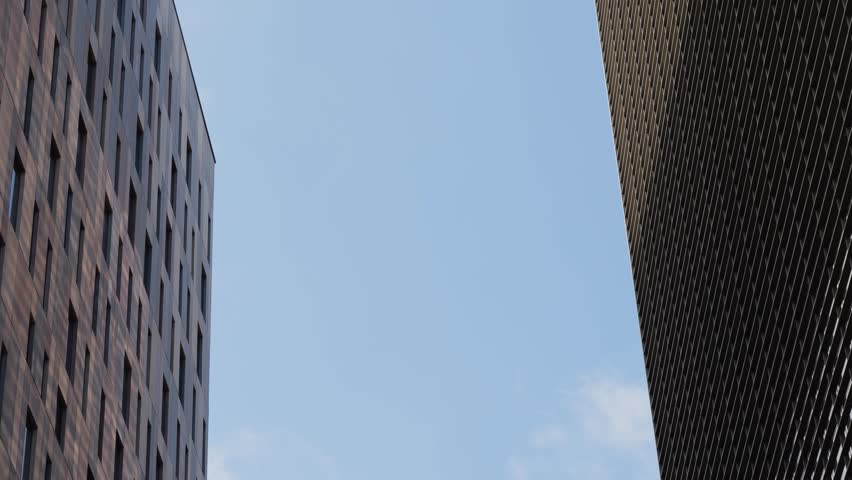 Modern glass office scyscraper buildings beautifully reflecting the clear blue sky in an urban environment